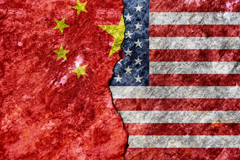 Flag of USA and China on cracked concrete wall background. Concept conflicts of two superpowers.